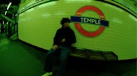 a man sitting on a bench in a subway station